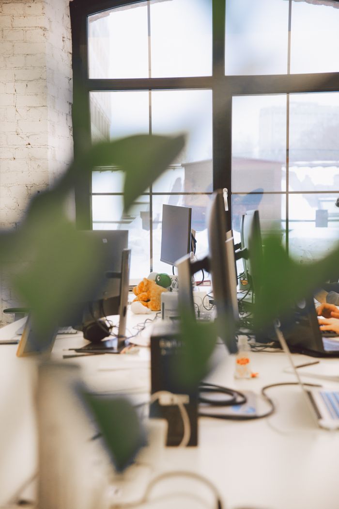 Contemporary office interior with blurred foreground and natural lighting through large windows.